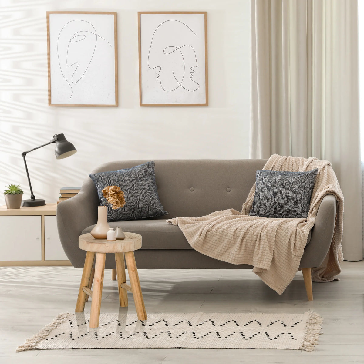 Brauner Sitzhocker RUSTIKO W aus Holz als Beistelltisch vor einem grauen Sofa von hjh LIVING